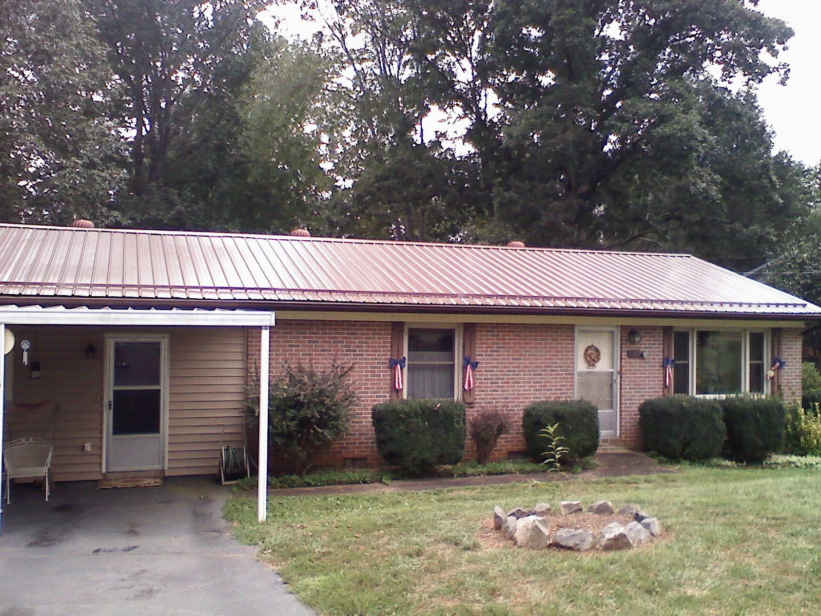 Bronze metal roof and carport on a brick ranch home — Roof Repair work by our crew in West Bloomfield